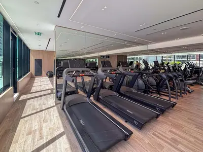 a gym with rows of treadmills in a building at Frank Porter - Binghatti Corner in Dubai