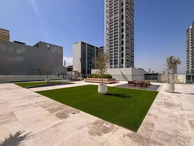 a courtyard in a city with tall buildings at Frank Porter - Binghatti Corner in Dubai