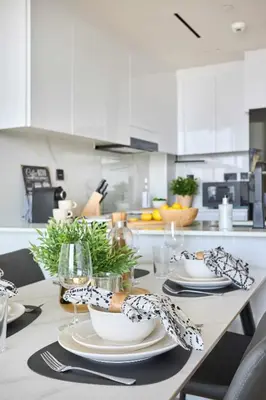 a kitchen with a table with plates and utensils at Frank Porter - Binghatti Corner in Dubai