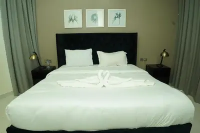 a large white bed with a white towel on it at Luxury 2BR Stay In Damac Prive near Dubai Mall in Dubai