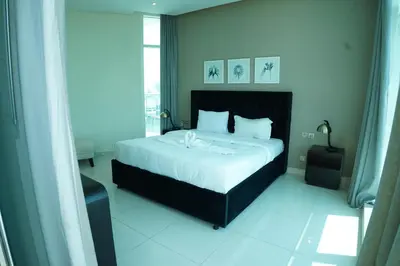 a bedroom with a large bed with white sheets at Luxury 2BR Stay In Damac Prive near Dubai Mall in Dubai