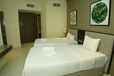 two beds in a hotel room with white sheets at Luxury 2BR Stay In Damac Prive near Dubai Mall in Dubai