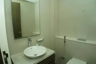 a white bathroom with a sink and a mirror at Luxury 2BR Stay In Damac Prive near Dubai Mall in Dubai