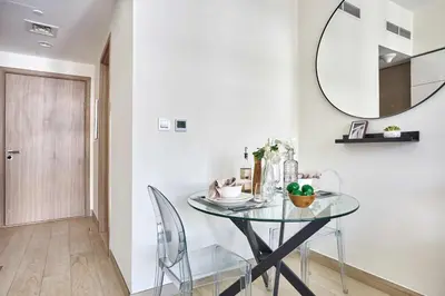 a dining room with a glass table and a mirror at Frank Porter - Azizi Riviera 15 in Dubai