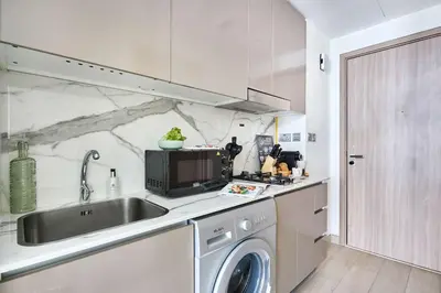 a kitchen with a sink and a washing machine at Frank Porter - Azizi Riviera 15 in Dubai