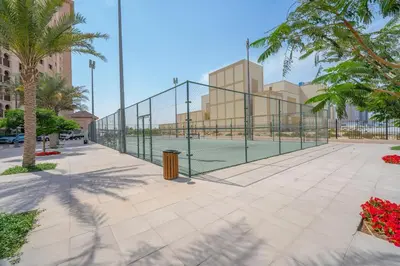 a tennis court with a net on a court at 1BHK Luxury Serviced Apartment - Al Andalus JGE in Dubai