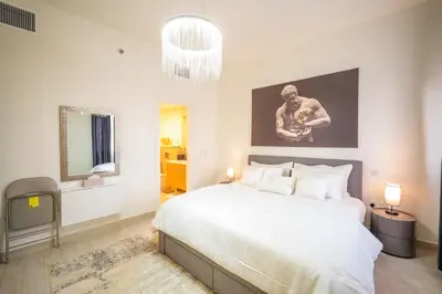 a bedroom with a large bed and a television at 1BHK Luxury Serviced Apartment - Al Andalus JGE in Dubai