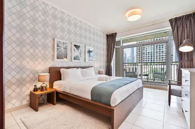 a bedroom with a large bed and a balcony at Vibrant 1BR APT with Burj Khalifa View in Dubai