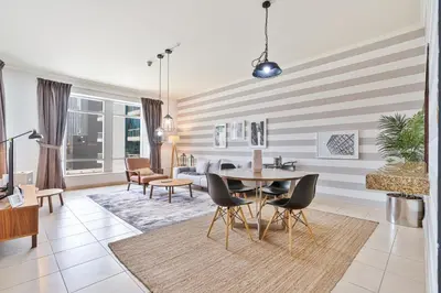 a living room with a table and chairs at Vibrant 1BR APT with Burj Khalifa View in Dubai