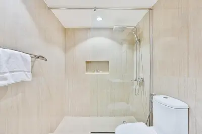 a bathroom with a shower and a white toilet at Vibrant 1BR APT with Burj Khalifa View in Dubai