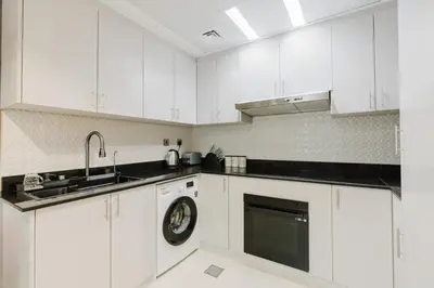 a white kitchen with a sink and a dishwasher at RH- Heart of Dubai Marina, Sunny & bright 2 BR apartment with big balcony in Dubai