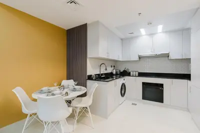 a kitchen with a table and chairs and a sink at RH- Heart of Dubai Marina, Sunny & bright 2 BR apartment with big balcony in Dubai