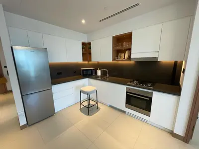 a kitchen with white cabinets and a stool in it at Vida Dubai Marina Apartment at Prime Location in Dubai