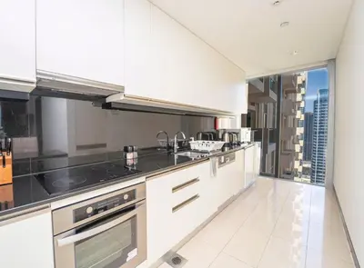 a kitchen with white cabinets and a view of the city at AWS Holiday Homes - Views from the Sky in Dubai