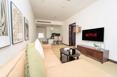 a living room with a couch and a tv on a wall at AWS Holiday Homes - Views from the Sky in Dubai