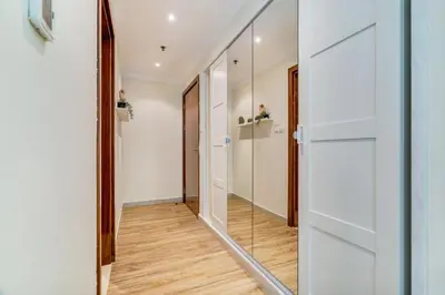 a hallway with a glass door and a mirror at GuestReady - Contemporary living in Dubai Marina in Dubai