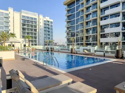 a swimming pool with lounge chairs and buildings at FIRST CLASS Studio Urban Elegance in Dubai