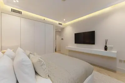 a bedroom with a bed and a tv on a wall at Daniels 4BR At Princess Tower with Marina and Sea view in Dubai