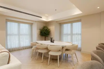 a dining room with a white table and chairs at Daniels 4BR At Princess Tower with Marina and Sea view in Dubai