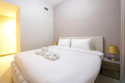 a white bed with a towel on top of it at Stylish 2BR Apartment by Missoni near Dubai Mall in Dubai