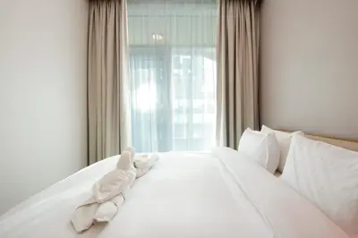 a white bed with white pillows and a window at Stylish 2BR Apartment by Missoni near Dubai Mall in Dubai