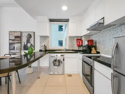a kitchen with a washer and dryer in it at Modern 1BR Oasis II Huge Layout II City Lights in Dubai