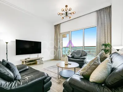 a living room with leather furniture and a flat screen tv at Modern 1BR Oasis II Huge Layout II City Lights in Dubai