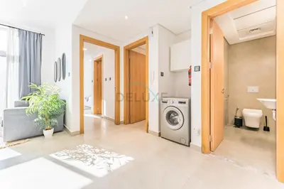 a laundry room with a washing machine in it at Balcony Offering Community Views 1BR with Assistant Room, Walking Distance to Community Park , Pantheon Elysee , Jumeirah Village Circle by Deluxe Holiday Homes in Dubai