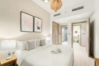 a white bedroom with a white bed and a bathroom at FIRST CLASS 1BR Elegant Marina Hideaway in Dubai