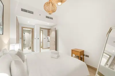 a white bedroom with a white bed and a mirror at FIRST CLASS 1BR Elegant Marina Hideaway in Dubai