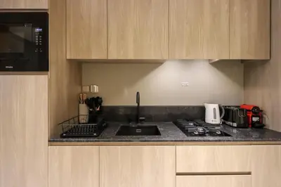 a kitchen with a sink and a stove top oven at Livbnb - Serene Studio with Private Terrace in JVC in Dubai