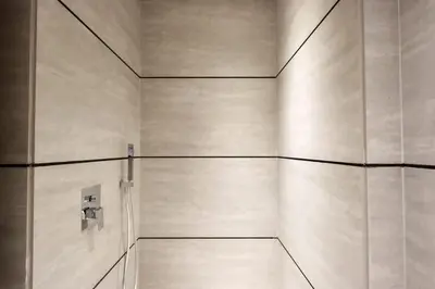 a bathroom with a shower with white walls at Livbnb - Serene Studio with Private Terrace in JVC in Dubai