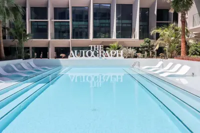 a swimming pool in front of a building at Livbnb - Serene Studio with Private Terrace in JVC in Dubai
