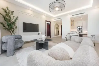 a living room with a couch and a tv at AirDXB - Luxurious 2-Bedroom Apartment in Downtown - Sleeps 4 with Iconic Burj Khalifa Views in Dubai