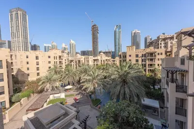 a view of a city with palm trees and buildings at AirDXB - Luxurious 2-Bedroom Apartment in Downtown - Sleeps 4 with Iconic Burj Khalifa Views in Dubai