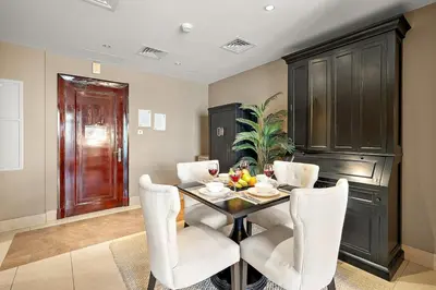 a dining room with a black table and white chairs at Charming Old Town Dubai 2BR Retreat with Burj Khalifa Balcony View in Dubai