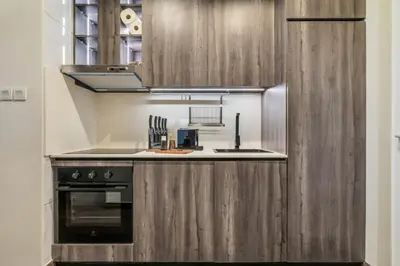 a kitchen with wooden cabinets and a stove at GuestReady - West Side Studios in Palm Jumeirah in Dubai