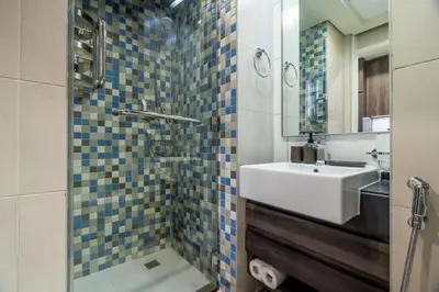 a bathroom with a sink and a shower with a mirror at GuestReady - West Side Studios in Palm Jumeirah in Dubai