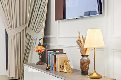 a table with a lamp and books on it at Premium 1BR with Iconic Skyline Views with Balcony & Pool in Dubai