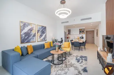 a living room with a blue couch and a table at Vogue Downtown Views II with Direct Access to Dubai Mall Via a Climate Controlled Bridge, Two Bedroom Apartment with Balcony and Burj Khalifa View in Dubai