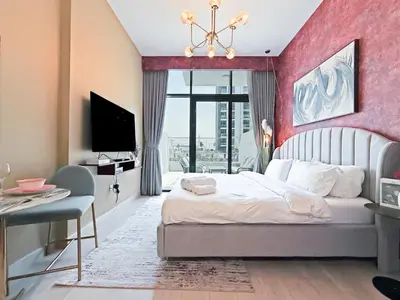 a bedroom with a large bed with a pink wall at Prime Studio Apt at Azizi Riviera 45, Meydan in Dubai