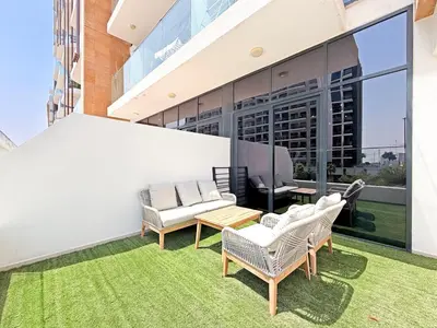 a balcony with chairs and tables on a building at Prime Studio Apt at Azizi Riviera 45, Meydan in Dubai