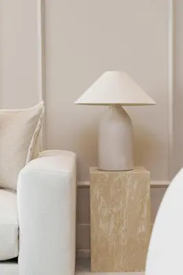 a lamp sitting on a table next to a couch at Daniels 1BR at Shoreline with Sea View in Dubai