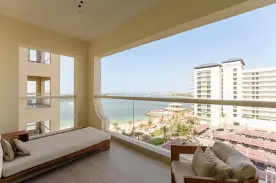 a bedroom with a large window with a view of the beach at Daniels 1BR at Shoreline with Sea View in Dubai