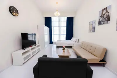 a living room with a couch and a tv at MK Residence JVC in Dubai