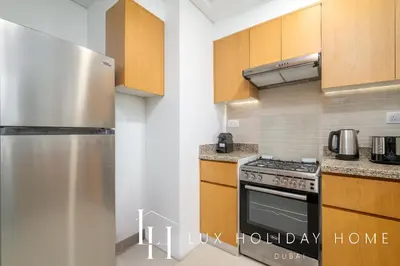a kitchen with a stainless steel refrigerator and cabinets at LUX The Executive Burj Khalifa View Suite 2 in Dubai