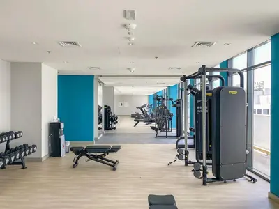 a gym with a row of treadmills and machines at Stunning Luxury Studio in Dubai in Dubai