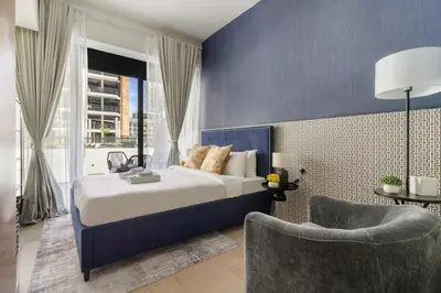 a blue bedroom with a bed and a chair at Stunning Luxury Studio in Dubai in Dubai