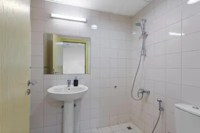 a white bathroom with a sink and a shower at Serene 2-bedroom Escape with Sea Steps Away in JBR in Dubai