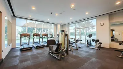 a gym with several treadmills and elliptical machines at Serene 2-bedroom Escape with Sea Steps Away in JBR in Dubai